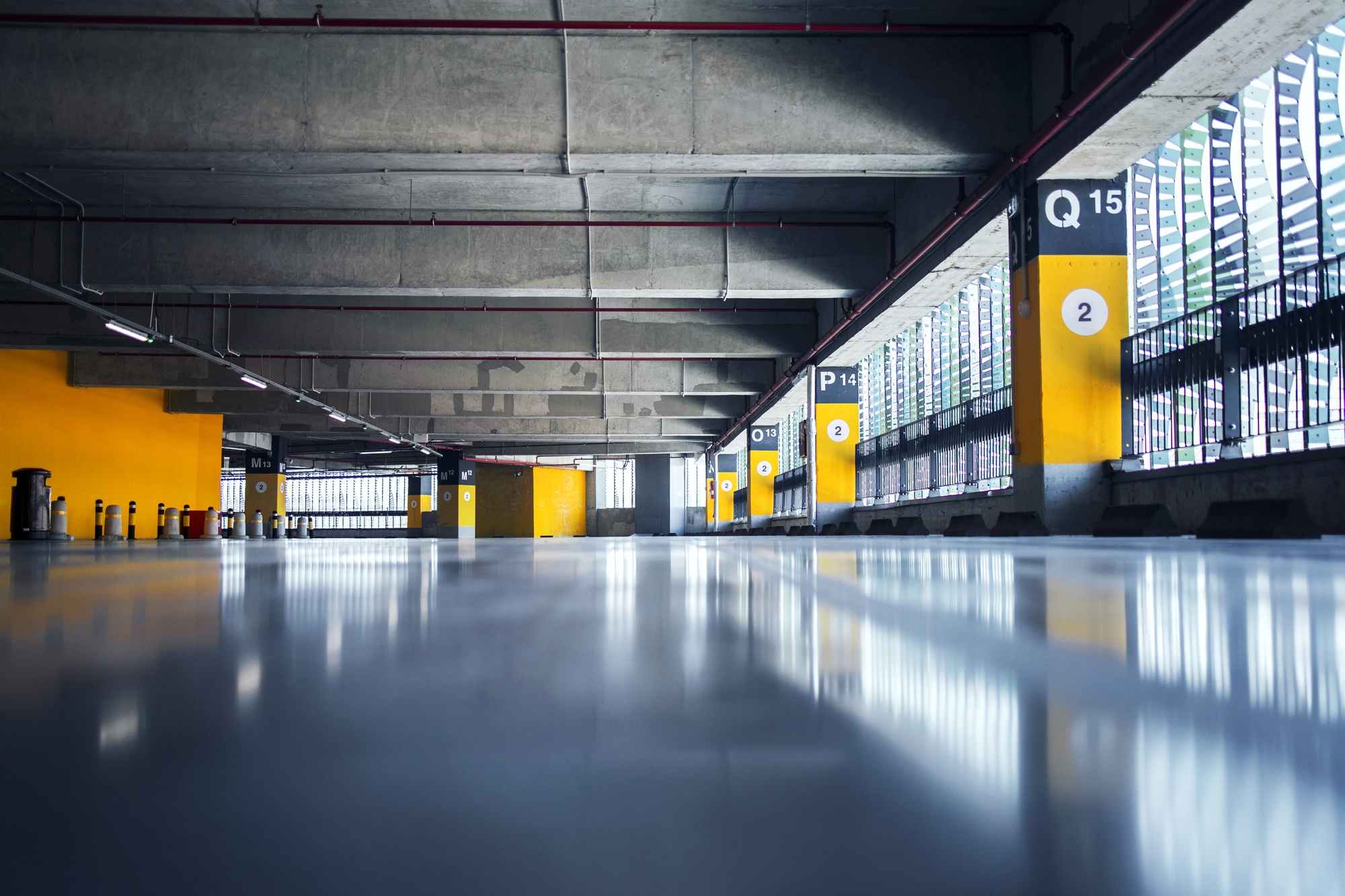 empty-garage-with-parking-lots-with-concrete-ceiling-flooring-pillars-marked-with-numbers_342744-1241